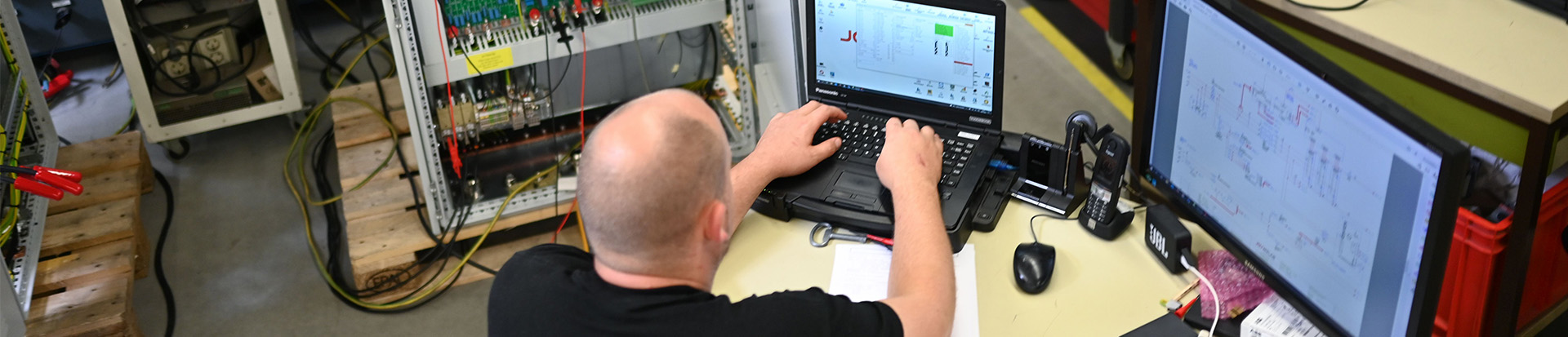 Mitarbeiter sitzt an einem Laptop und arbeitet / Employee works on a laptop